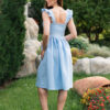 Woman in a garden, dressed in blue linen dress