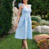 Woman in a garden, dressed in blue linen dress