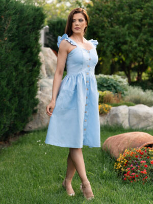Woman in a garden, dressed in blue linen dress