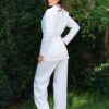 Woman dressed in white linen jacket and white pants