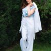 Woman dressed in white linen jacket, blue shirt and white pants