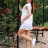 Woman in a garden dressed in white linen shorts and white linen top