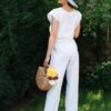 Woman in a garden dressed in white linen pants and white linen top