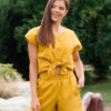Woman dressed in yellow linen shirt with longs sleeves and coconut buttons and yellow pants