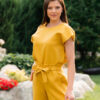Woman dressed in yellow linen shirt with longs sleeves and coconut buttons and yellow pants