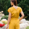 Woman dressed in yellow linen shirt with longs sleeves and coconut buttons and yellow pants