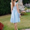 Woman in a garden, dressed in blue linen dress