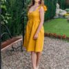 Woman in a garden, dressed in yellow linen dress