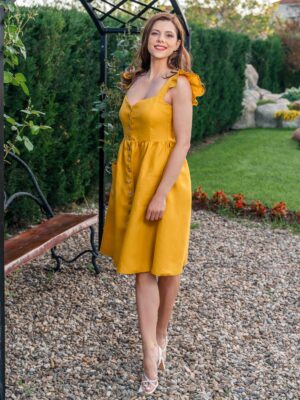 Woman in a garden, dressed in yellow linen dress