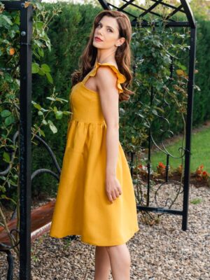 Woman in a garden, dressed in yellow linen dress