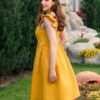 Woman in a garden, dressed in yellow linen dress