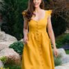 Woman in a garden, dressed in yellow linen dress