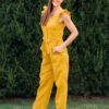 Woman in a garden dressed in linen yellow jumpsuit