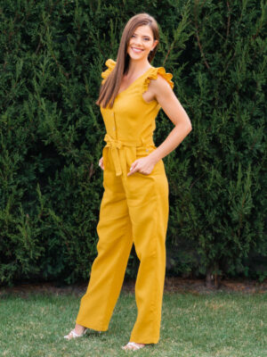 Woman in a garden dressed in linen yellow jumpsuit