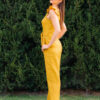 Woman in a garden dressed in linen yellow jumpsuit