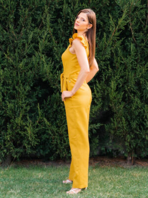 Woman in a garden dressed in linen yellow jumpsuit