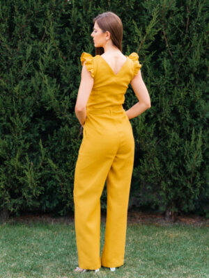 Woman in a garden dressed in linen yellow jumpsuit
