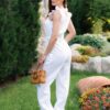Woman in a garden dressed in linen white jumpsuit
