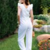 Woman in a garden dressed in linen white jumpsuit
