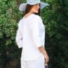 Woman dressed in white linen shirt with long sleeves and white long pants