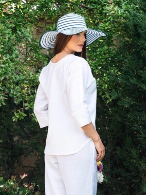 Woman dressed in white linen shirt with long sleeves and white long pants