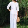 Woman dressed in white linen shirt with long sleeves and white long pants