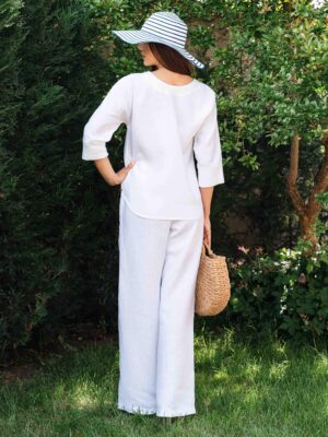 Woman dressed in white linen shirt with long sleeves and white long pants