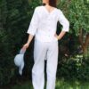 Woman dressed in white linen shirt with long sleeves and white long pants