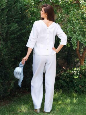 Woman dressed in white linen shirt with long sleeves and white long pants