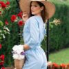 Woman dressed in blue linen shirt with long sleeves and blue long pants