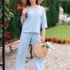 Woman dressed in blue linen shirt with long sleeves and blue long pants