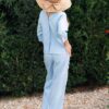 Woman dressed in blue linen shirt with long sleeves and blue long pants