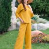 Woman dressed in yellow linen shirt with longs sleeves and coconut buttons and yellow long pants