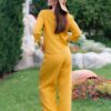 Woman dressed in yellow linen shirt with longs sleeves and coconut buttons and yellow long pants