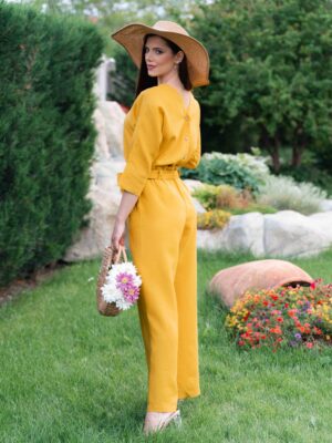 Woman dressed in yellow linen shirt with longs sleeves and coconut buttons and yellow long pants