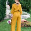 Woman dressed in yellow linen shirt with longs sleeves and coconut buttons and yellow long pants