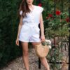 Woman in a garden dressed in white linen shorts and white linen top