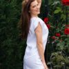 Woman in a garden dressed in white linen shorts and white linen top