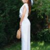 Woman dressed in white linen shirt with short sleeves and white long pants