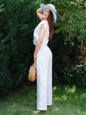 Woman dressed in white linen shirt with short sleeves and white long pants