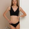 Woman dressed in organic cotton black brazilian bikini and black top