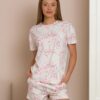 Woman wearing two-piece organic cotton summer pajamas with floral patterns