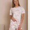 Woman wearing two-piece organic cotton summer pajamas with floral patterns