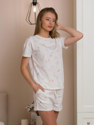 A woman wearing a two-piece organic cotton summer pajama set in a tropical nautical pattern