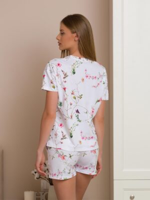 Woman wearing two-piece organic cotton summer pajamas with floral patterns