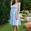 Woman in a garden, dressed in blue linen dress