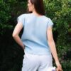 Woman in a garden dressed in white linen shorts and blue linen shirt