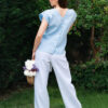 Woman in a garden dressed in white linen shorts and blue linen shirt