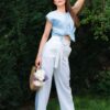 Woman in a garden dressed in white linen shorts and blue linen shirt