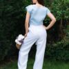 Woman in a garden dressed in white linen shorts and blue linen shirt